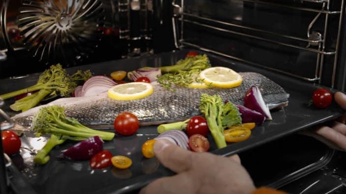 Tillagad fisk tas ut ur ugnen