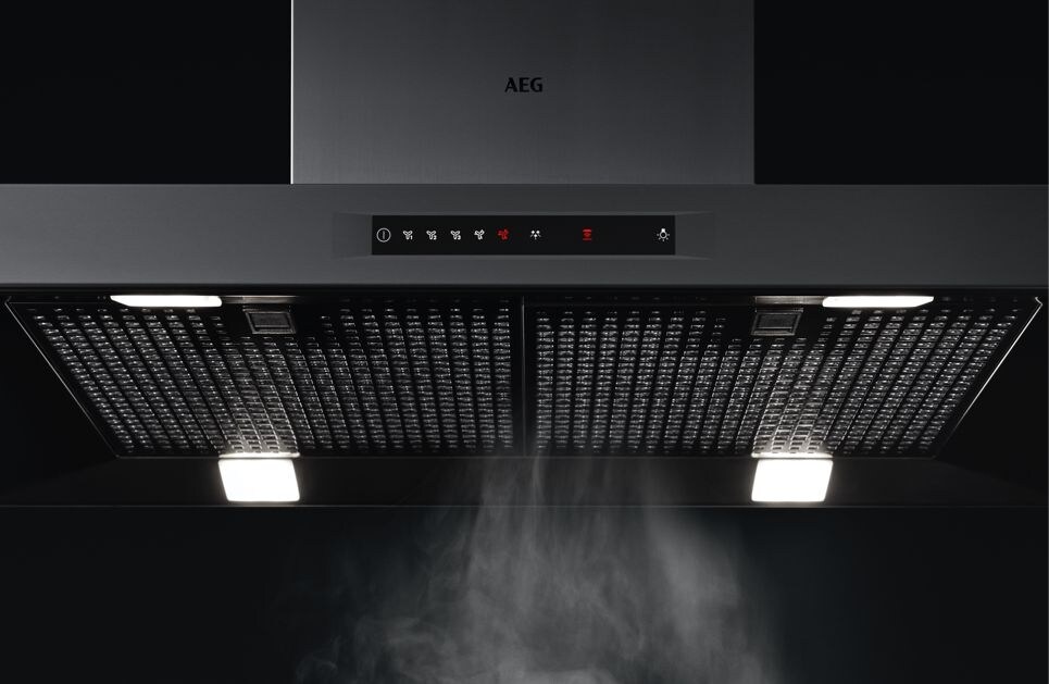 Kjøkkenventilator trekker damp fra matretten på den keramiske koketoppen Kjøkkenventilator trekker damp fra matretten på den keramiske koketoppen