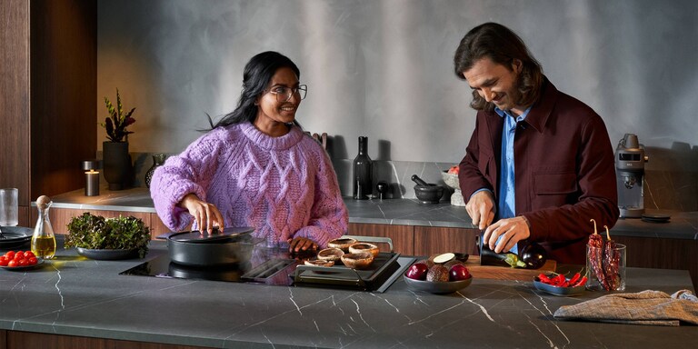 Mann og kvinne lager mat på kjøkkenet