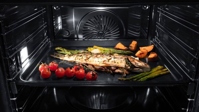 Nærbilde av damptilberedning og et stekebrett.