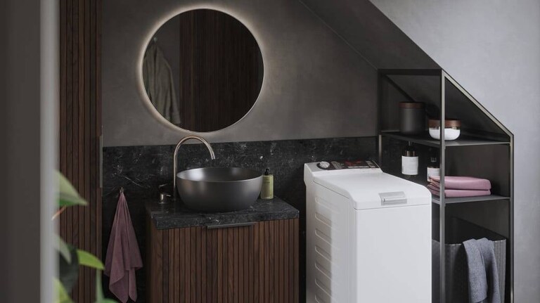 En toppmatet vaskemaskin fra AEG står på et bad.