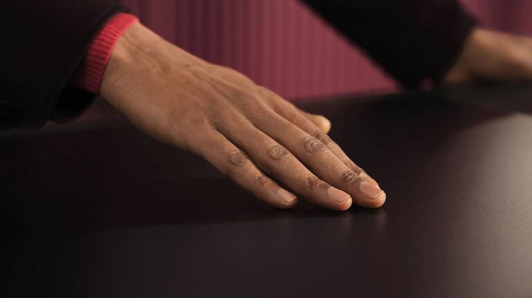 En person berører en induksjonstopp med ripebestandig overflate.